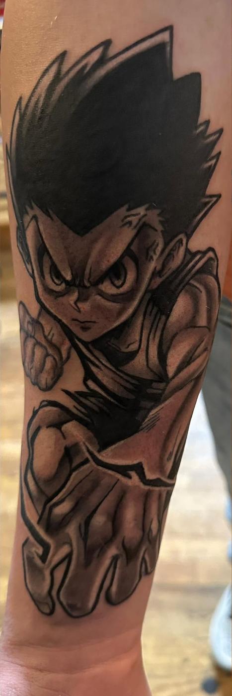 Anime character mid-swing, in black and gray with heavy outlines, on a forearm